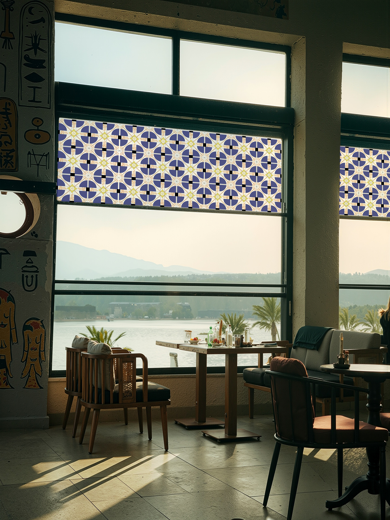 Between Lights installed across large windows, filtering sunlight through a repeating solar pattern