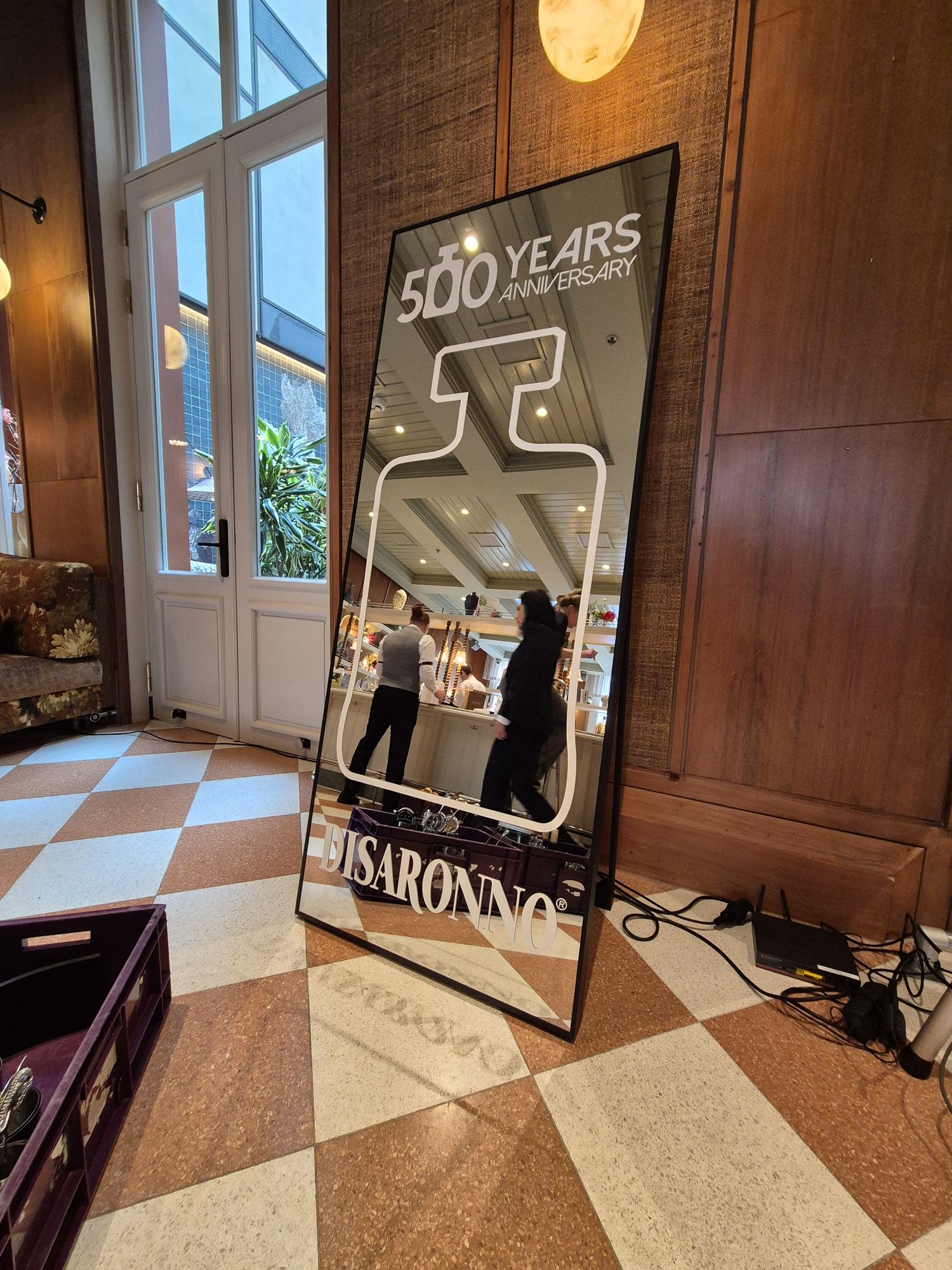 Full-length Disaronno anniversary mirror shaped with a bottle outline