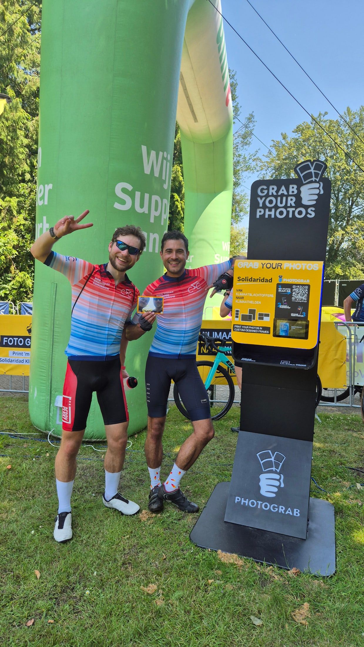 Guests posing beside a branded PHOTOGRAB station at an outdoor event