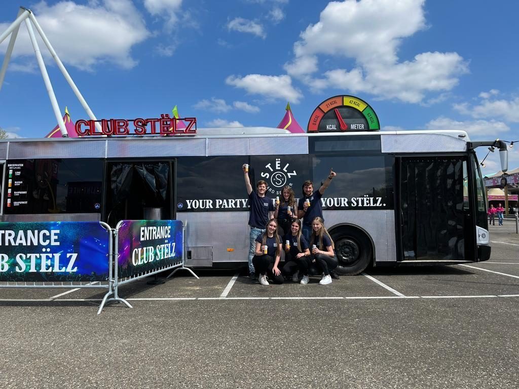 Club Stëlz event bus with the large analogue timer mounted on its roof and the production team in front