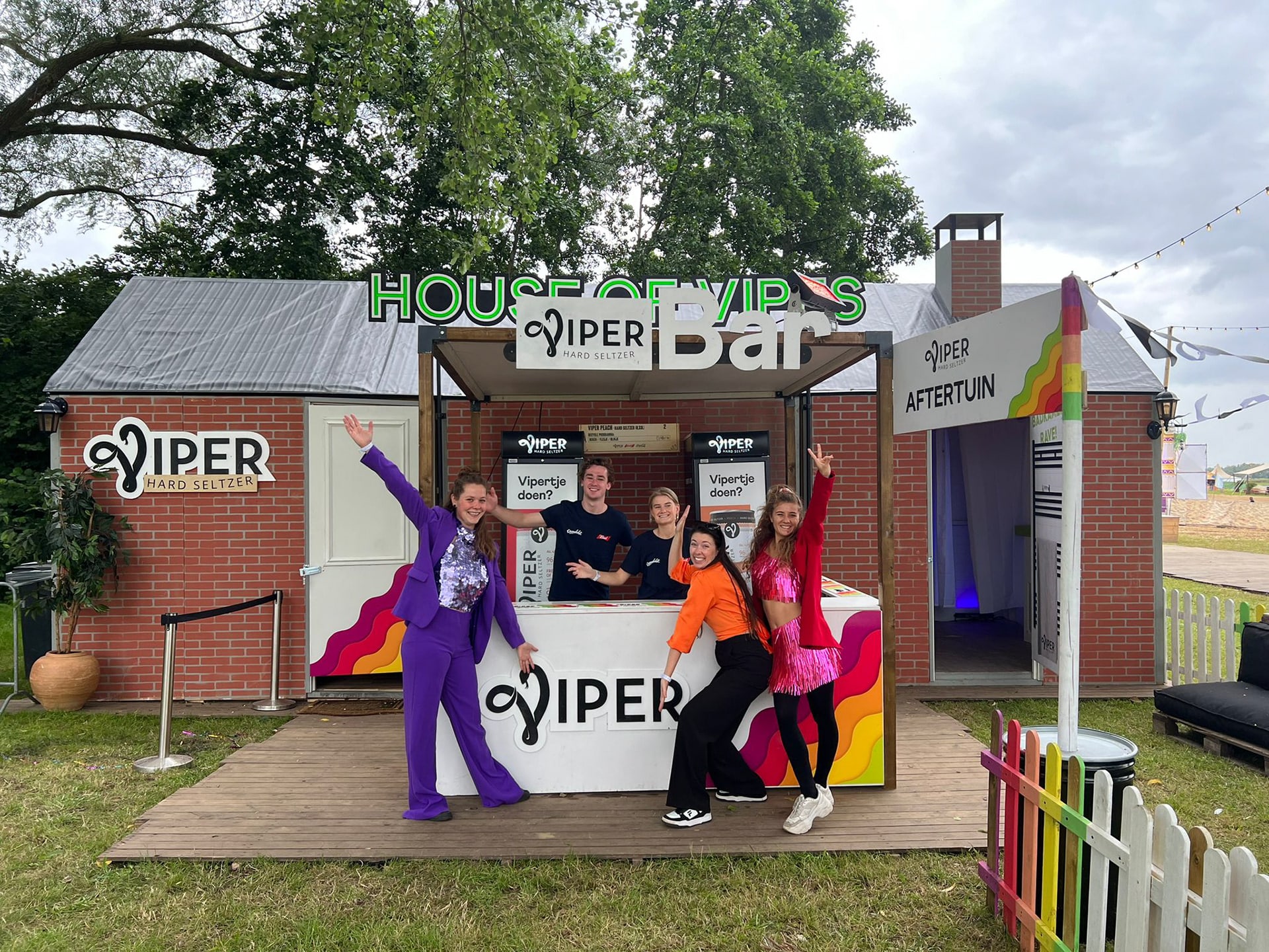 Viperhuis exterior with the production team in front of the three-room festival activation